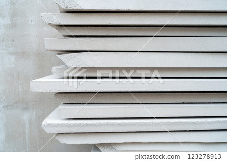 Stack of fiber cement boards resting on wooden surface 123278913
