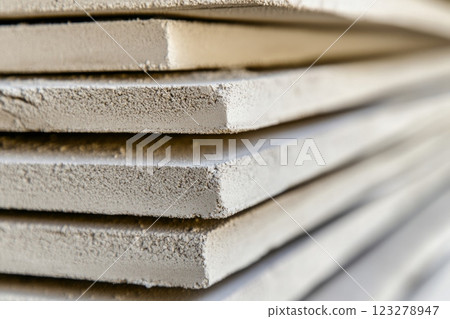 Stack of fiber cement boards resting on wooden surface 123278947