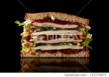 Delicious turkey sandwich stacked high with cranberry sauce and stuffing on whole wheat bread 123279073