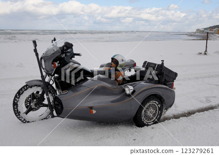 A sidecar standing on a snowy field with a view of the sea A sidecar standing on a snowy field with a view of the sea 123279261