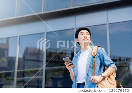 Portrait of handsome Asian student using smartphone 123279570