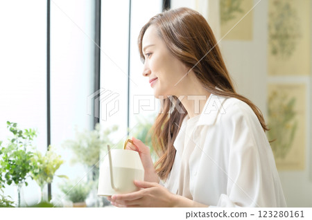 A woman enjoying gardening while watering plants 123280161