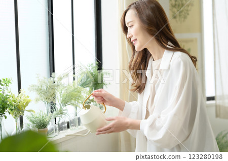 A woman enjoying gardening while watering plants 123280198