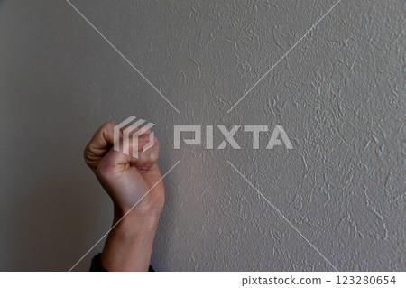 握緊拳頭，抵住昏暗的牆壁 123280654
