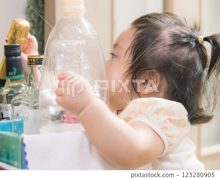 [Baby with twin tails standing up in the kitchen] 123280905
