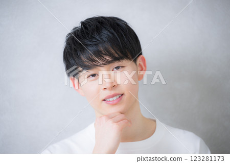 一個男人用手托著下巴看著相機 - 美麗和美麗的圖像 123281173