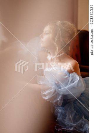 Portrait of an elegant woman in a light blue ball gown in a classic interior Portrait of an elegant woman in a light blue ball gown in a classic interior 123281525