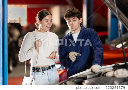 woman consults a mechanic in a car service 123281879