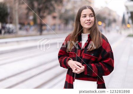 woman stands at a public transport stop woman stands at a public transport stop 123281898