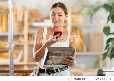 Woman checks calories in cookies using app on phone Woman checks calories in cookies using app on phone 123281924