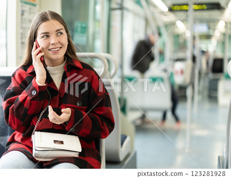 Girl sit in tram car and emotionally talks on phone, getting to work Girl sit in tram car and emotionally talks on phone, getting to work 123281928
