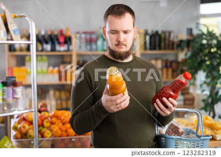 Man choosing juice in the store 123282319