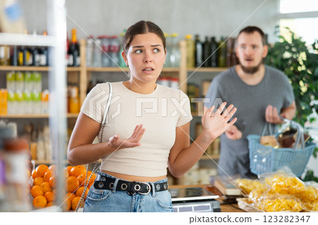 Sullen girl stands with arms crossed on chest, swears with husband and listens to mans accusations Sullen girl stands with arms crossed on chest, swears with husband and listens to mans accusations 123282347