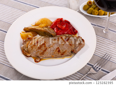 Delicious mediterranian style steak served with baked tomatoes and onions 123282395