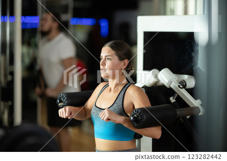 Woman training her hands in the machine 123282442