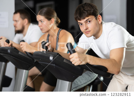 Guy is exercising on an exercise bike 123282911
