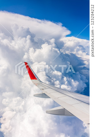 View from the airplane window at a beautiful cloudy sky and the airplane wing 123284212