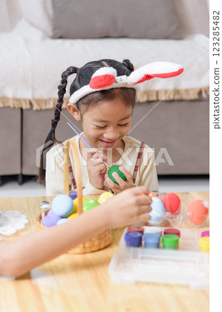 Easter memories. A mother and child celebrate Easter by painting eggs in colorful shades 123285482