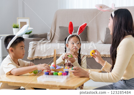 Easter memories. A mother and child celebrate Easter by painting eggs in colorful shades 123285484