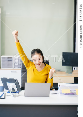 Asian Businesswoman Analyzing Finance on Tablet and Laptop at modern Office Desk tax Asian Businesswoman Analyzing Finance on Tablet and Laptop at modern Office Desk tax 123286150