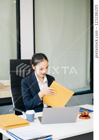 female lawyer celebrating success with documents at a desk, featuring a gavel, scales of justice, female lawyer celebrating success with documents at a desk, featuring a gavel, scales of justice, 123286205