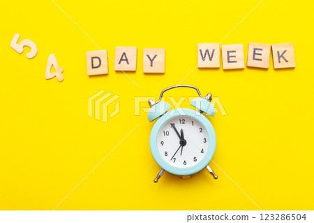 inscription four day week making by wooden cubes on yellow background inscription four day week making by wooden cubes on yellow background 123286504