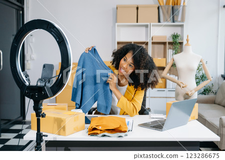 Fashion blogger concept, Young women selling clothes on video streaming.Startup small business SME, using smartphone or tablet taking Fashion blogger concept, Young women selling clothes on video streaming.Startup small business SME, using smartphone or tablet taking 123286675