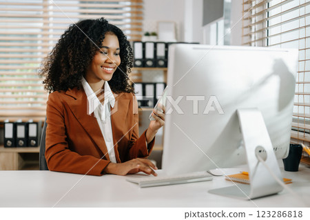 Businesswoman Analyzing Finance on Tablet and Laptop at modern Office Desk tax Businesswoman Analyzing Finance on Tablet and Laptop at modern Office Desk tax 123286818