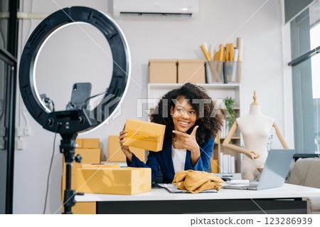 Woman blogger showing clothes in front of the camera to recording vlog video live streaming Woman blogger showing clothes in front of the camera to recording vlog video live streaming 123286939