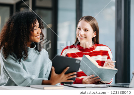 Two business workers talking on the smartphone and using laptop at office. Two business workers talking on the smartphone and using laptop at office. 123288040