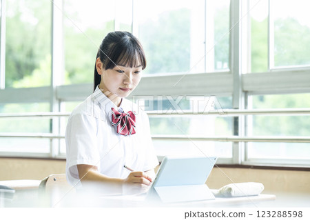 School girl who studies on tablet 123288598
