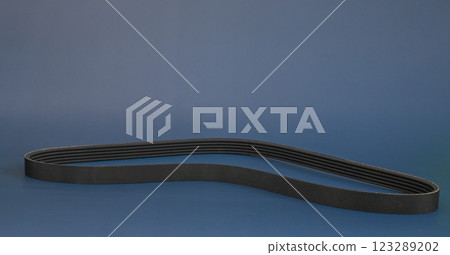 the car's generator belt. spare on a blue background. the car's generator belt. spare on a blue background. 123289202
