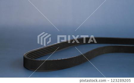 car's generator belt. spare parts on a blue background. car's generator belt. spare parts on a blue background. 123289205
