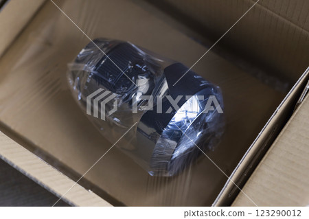 A camera lens packed in cardboard for repair A camera lens packed in cardboard for repair 123290012