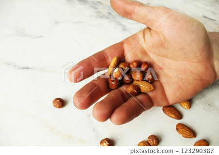 Nuts, almonds and fduk on the palm of your hand on a white background with space for copyspace text 123290387