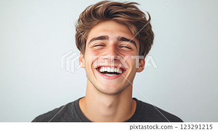 Young man's infectious laughter fills the frame, showcasing a moment of pure joy and highlighting his bright, genuine smile. 123291215