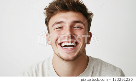 Bright smile illuminates this portrait of a young man, expressing pure joy and positive energy against a clean backdrop. Bright smile illuminates this portrait of a young man, expressing pure joy and positive energy against a clean backdrop. 123291220