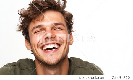Close-up of a happy, laughing man with messy brown hair against a bright white background, showcasing genuine emotion and radiant smile. Close-up of a happy, laughing man with messy brown hair against a bright white background, showcasing genuine emotion and radiant smile. 123291240