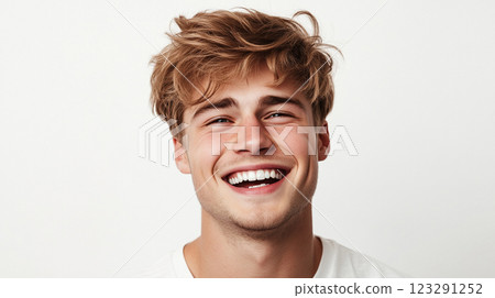 Radiant young man with sun-kissed hair beams with genuine joy in a bright, inviting portrait filled with positive energy. Perfect smile. Radiant young man with sun-kissed hair beams with genuine joy in a bright, inviting portrait filled with positive energy. Perfect smile. 123291252
