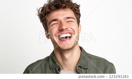 Man enjoying a hearty laugh with eyes closed. Casual style, expressive joy, creating a fun and inviting atmosphere of relatable happiness. 123291261