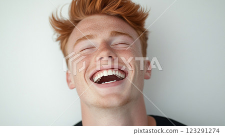 Close-up of a happy, laughing young man with red hair and freckles. He's got an infectious smile and bright white teeth. Such joy! Close-up of a happy, laughing young man with red hair and freckles. He's got an infectious smile and bright white teeth. Such joy! 123291274