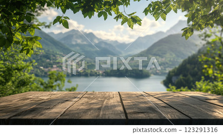 Wooden tabletop overlooking a serene lake surrounded by majestic mountains and lush greenery, creating a peaceful and inviting atmosphere. Wooden tabletop overlooking a serene lake surrounded by majestic mountains and lush greenery, creating a peaceful and inviting atmosphere. 123291316