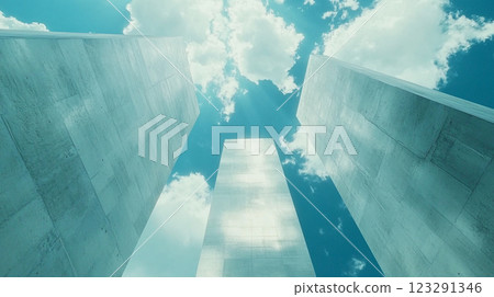 Monumental concrete structures rise against a vibrant blue sky with scattered clouds, creating a sense of scale and modern architecture. 123291346