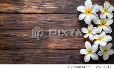 Floral Delight: Plumeria flowers on dark wood surface, adding elegance to rustic backgrounds. Ideal for serene design. Floral Delight: Plumeria flowers on dark wood surface, adding elegance to rustic backgrounds. Ideal for serene design. 123291717