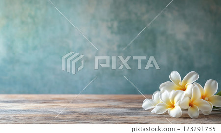 Delicate white blossoms cascade on weathered wood, blending nature's simplicity with rustic charm against a muted blue backdrop. 123291735