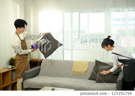 Happy asian couple cleaning and organizing their living room 123291794
