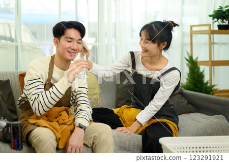 Loving asian couple resting on couch after finishing their household chores 123291921