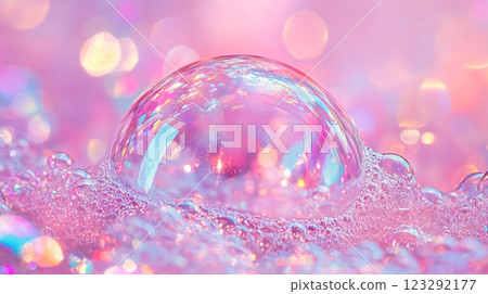 A pink, shimmering bubble reflecting light with soft focus background of bubbles, creating a dreamlike and magical aesthetic. 123292177