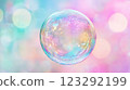 A shimmering bubble floats against a dreamy pastel backdrop, capturing light and color in a delicate iridescent sphere. 123292199