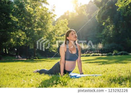 Young caucasian pregnant woman doing morning yoga in the park Young caucasian pregnant woman doing morning yoga in the park 123292226